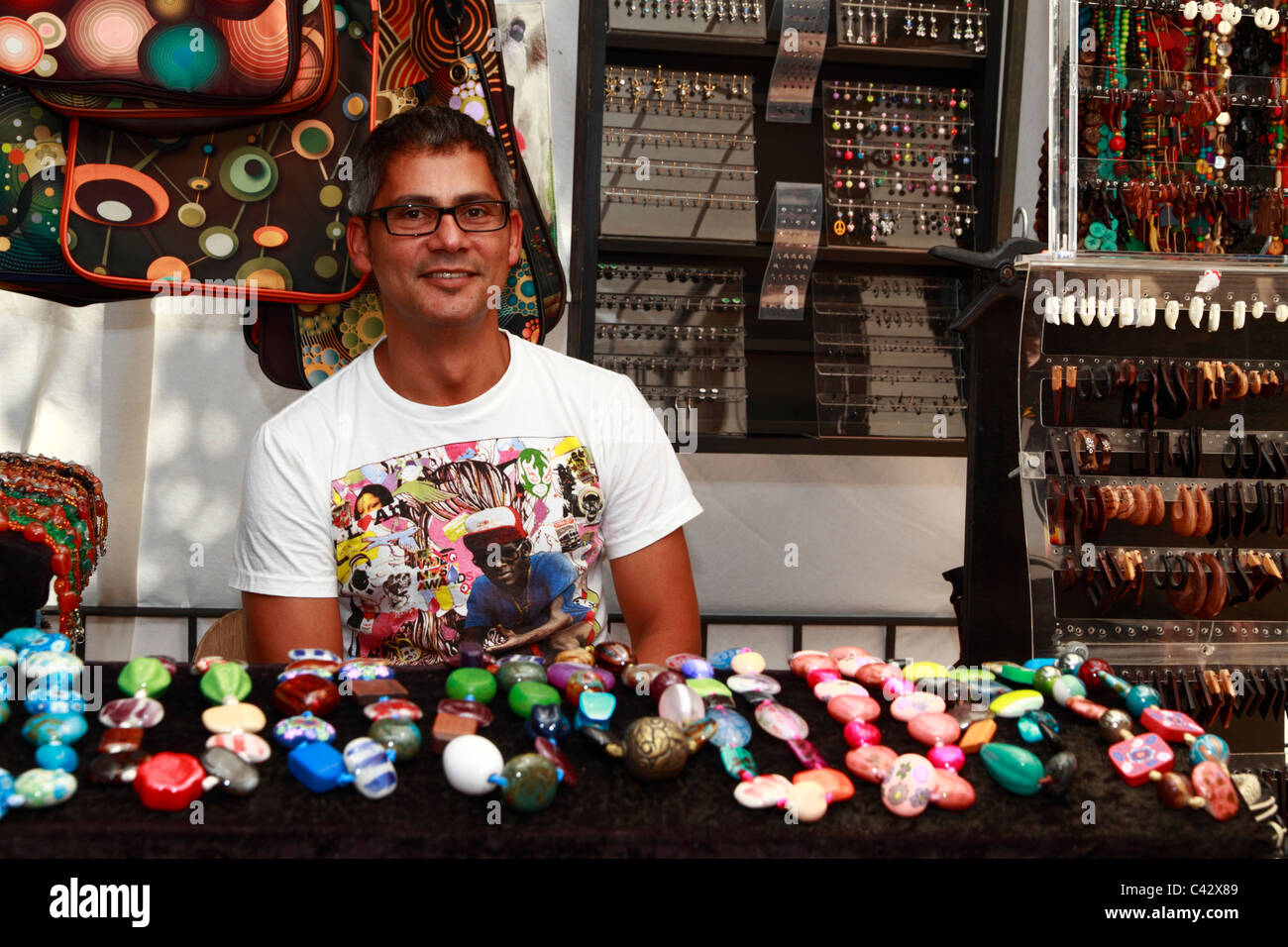 L'homme qui vendent des marchandises à un marché Hippie, Santa Eulalia, Ibiza, Espagne Banque D'Images