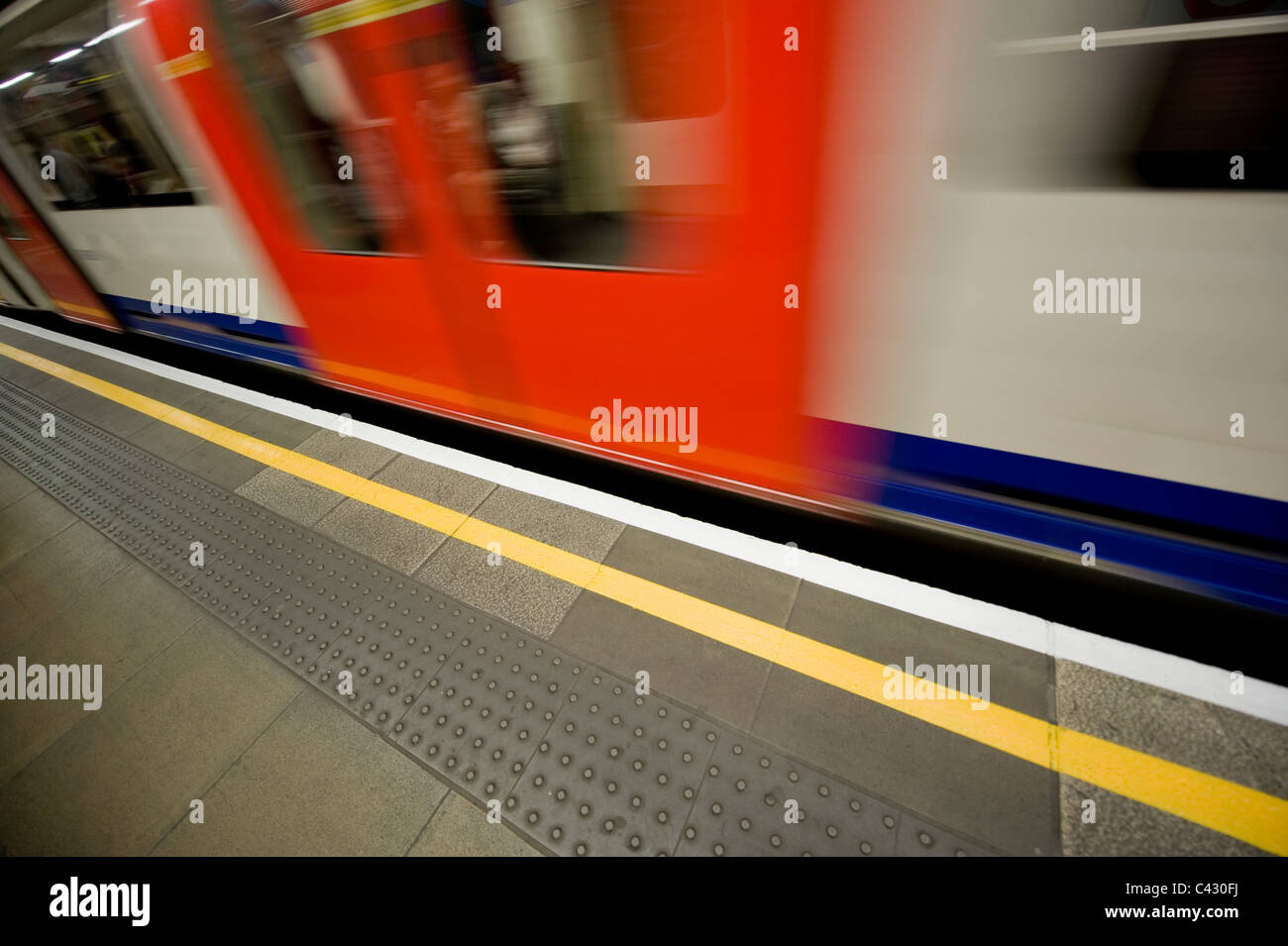 Métro de Londres, un train de tube s'engouffre dans une plate-forme de Londres. Banque D'Images
