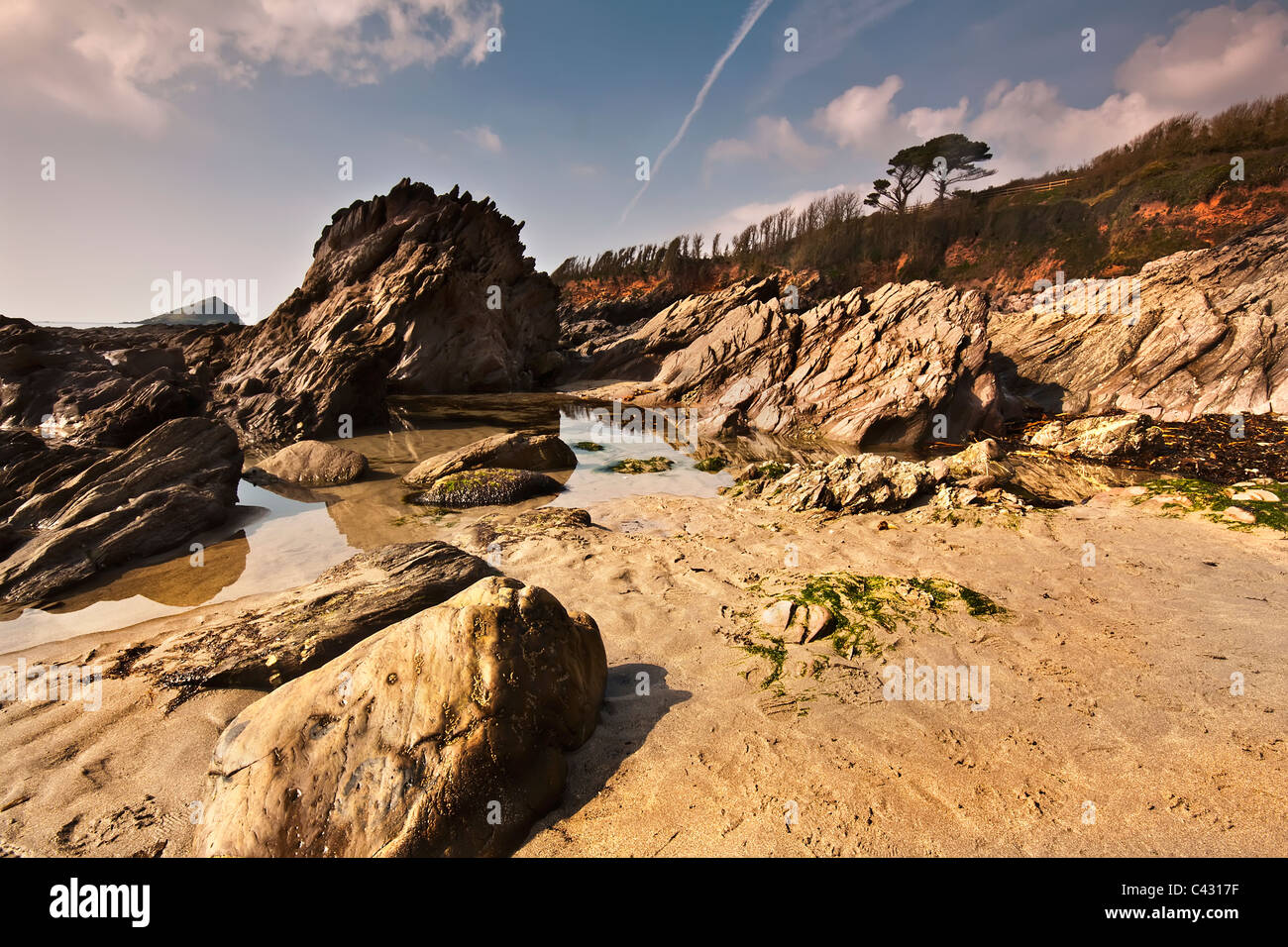 Tôt le matin voir de Wembury beach rocks menant vers la mer avec la grande Mewstone assis sur l'horizon Banque D'Images