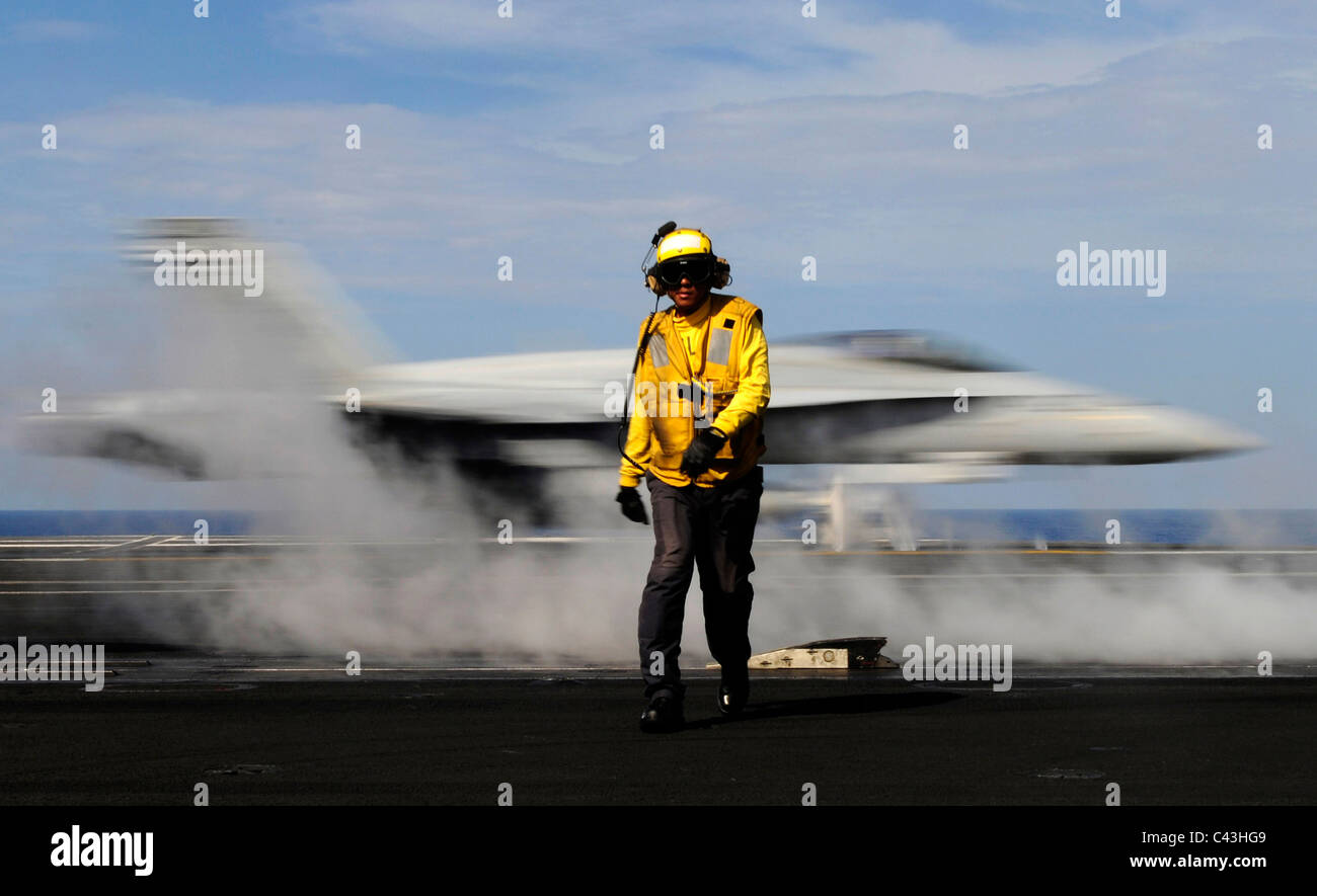 Montres marin le trouble d'un avion de chasse au décollage à partir du pont du porte-avions USS Carl Vinson. Banque D'Images
