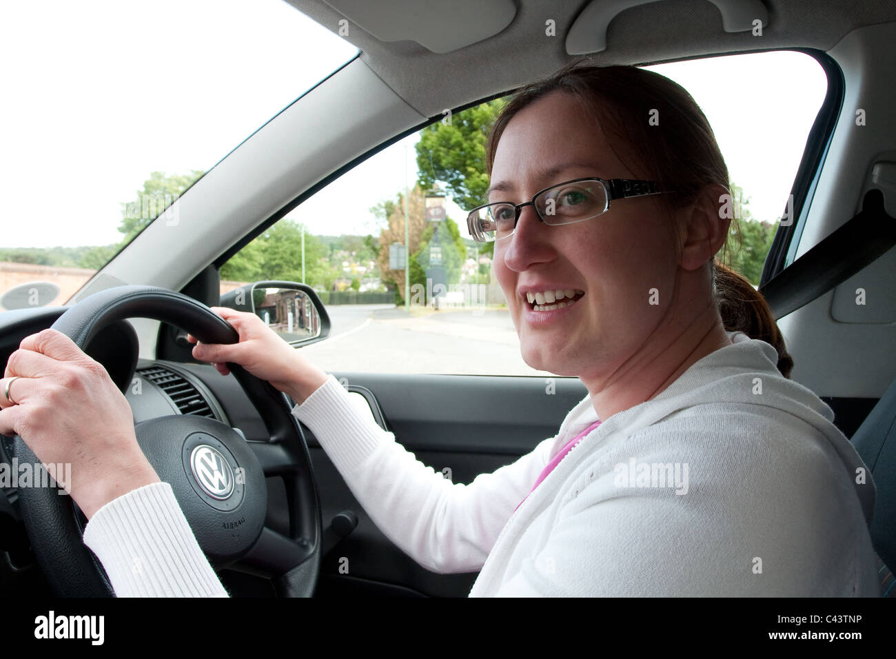Jeune femme au volant d'une VW Polo en UK Banque D'Images