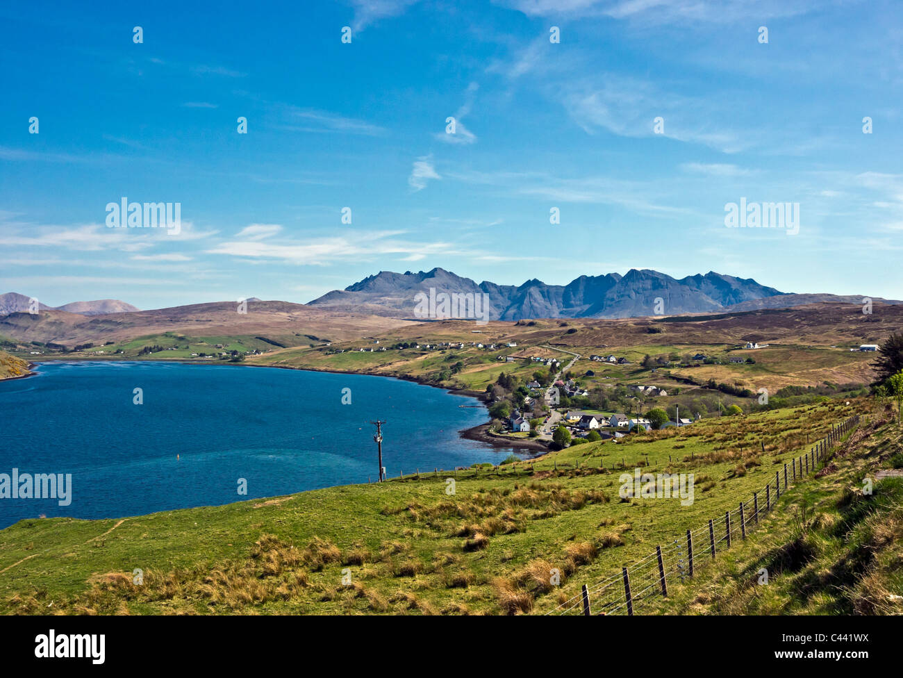 Vue du dessus vers le village de Skye Carbost Cuillin Hills avec la distillerie de Whisky Talisker au premier plan. Banque D'Images
