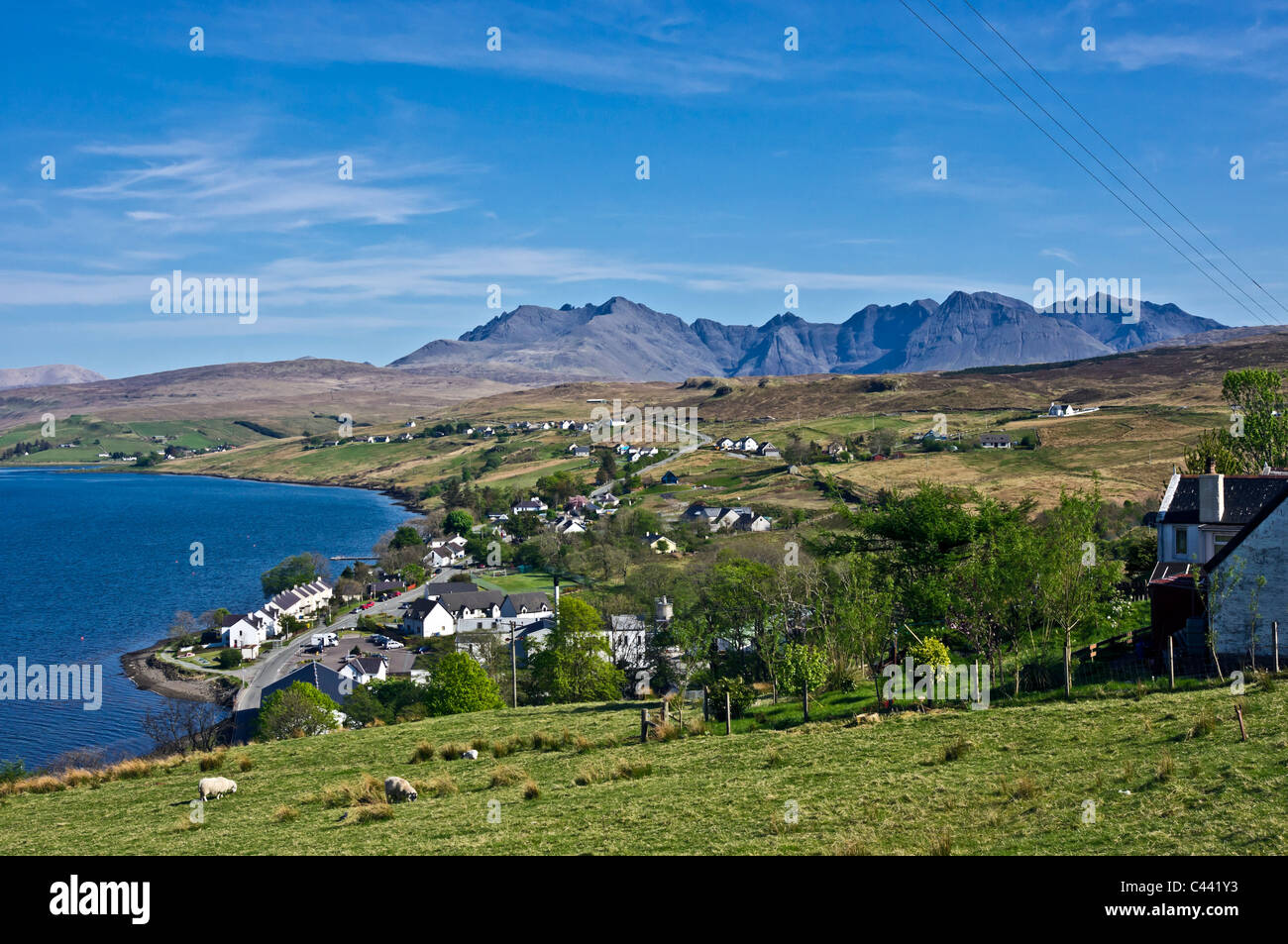 Vue du dessus vers le village de Skye Carbost Cuillin Hills avec la distillerie de Whisky Talisker au premier plan. Banque D'Images