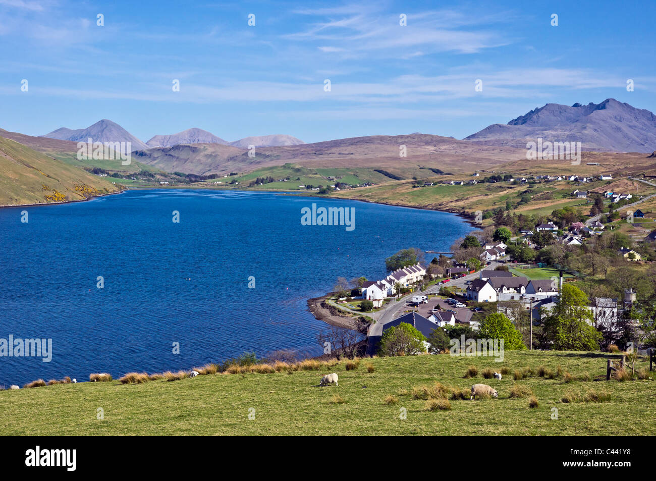 Vue du dessus vers le village de Skye Carbost Cuillin Hills avec la distillerie de Whisky Talisker au premier plan. Banque D'Images