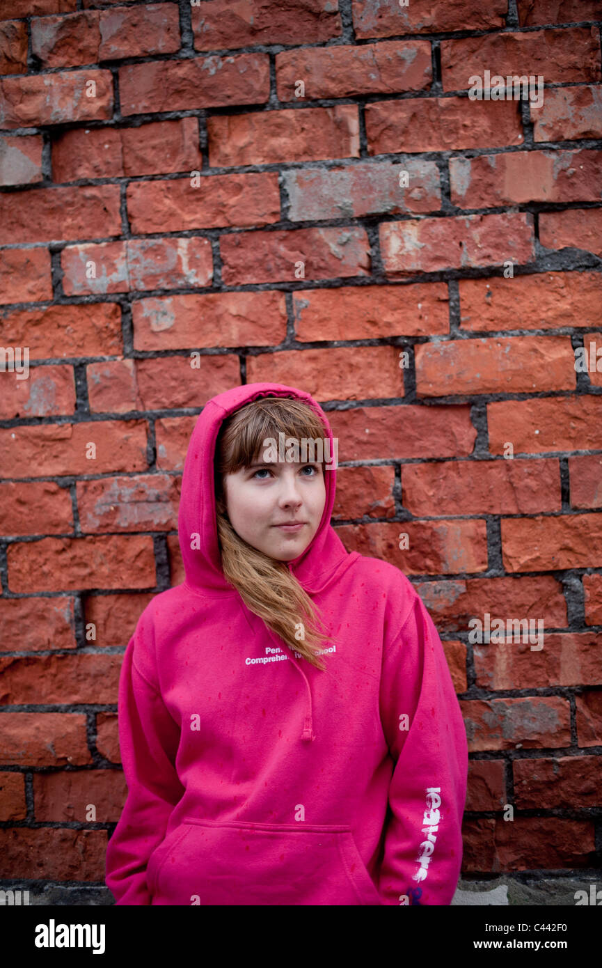 Une jeune fille portant un haut à Capuchon Sweat rose en face d'un mur de  briques, UK Photo Stock - Alamy