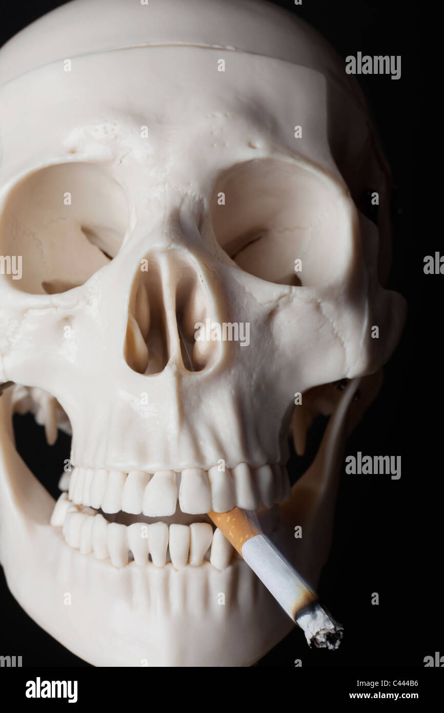 Un squelette de fumer une cigarette Banque D'Images