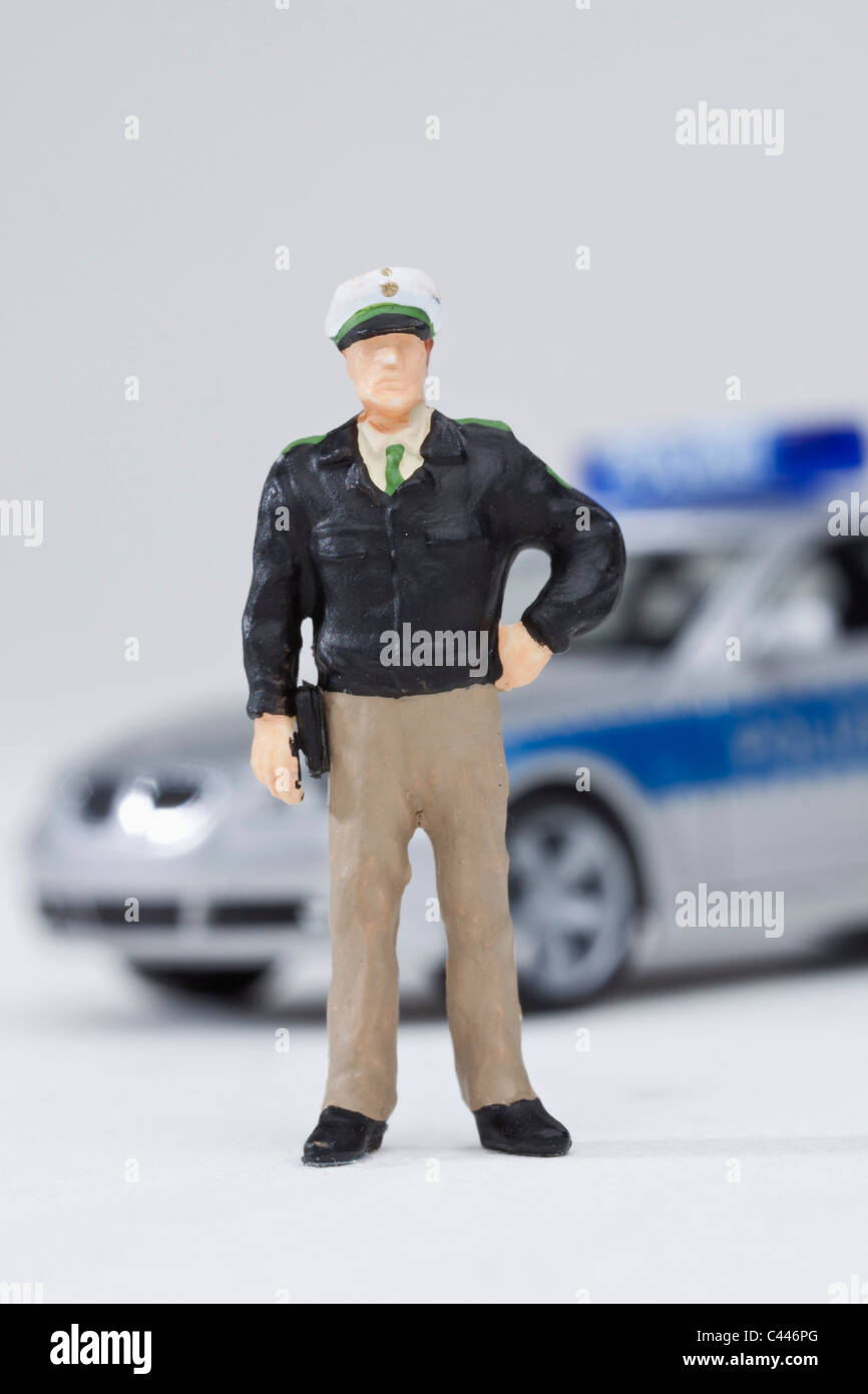 Un policier debout figurine miniature d'une voiture de police miniature Banque D'Images