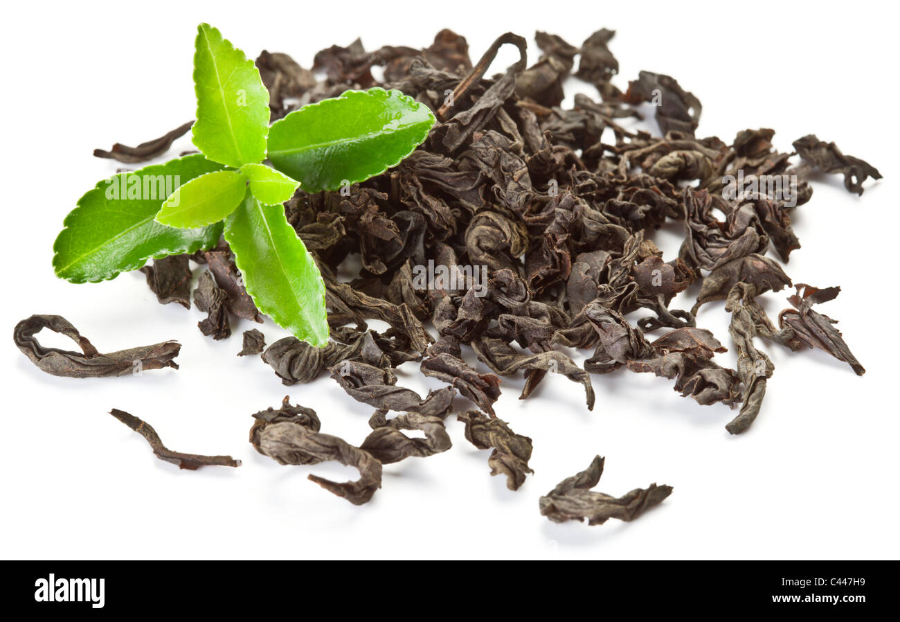 Tas de thé sec avec du thé vert feuilles isolées sur un fond blanc. Banque D'Images