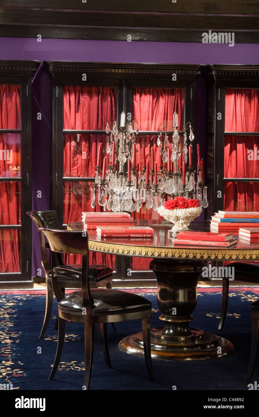 La façade de verre placards avec des rideaux en soie dans la salle à manger avec table à manger circulaire, candélabres et tapis bleu cristal Banque D'Images