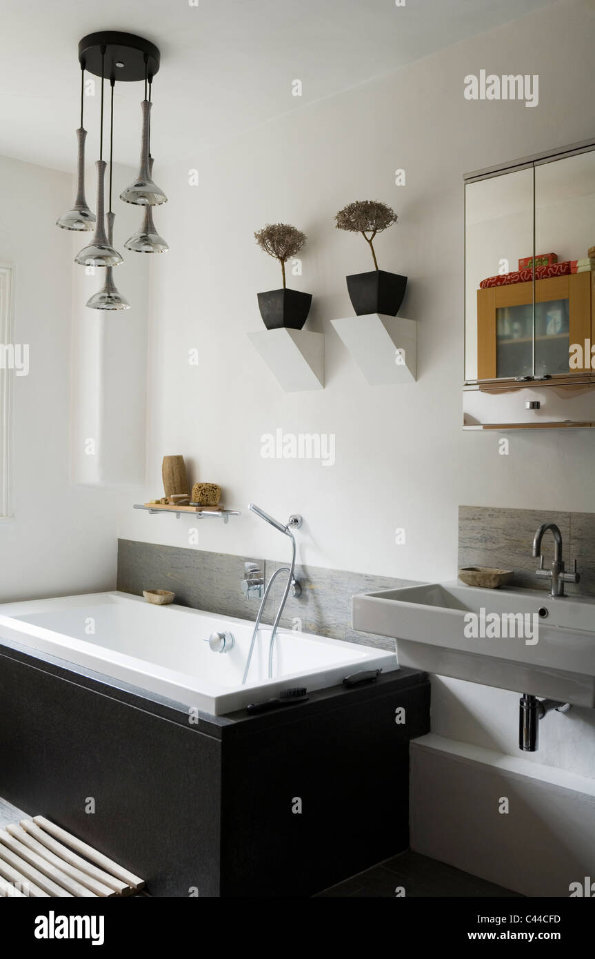 Pendentif rétro français luminaire blanc moderne dans une salle de bains privative avec baignoire, armoire miroir et lavabo en porte-à-faux Banque D'Images