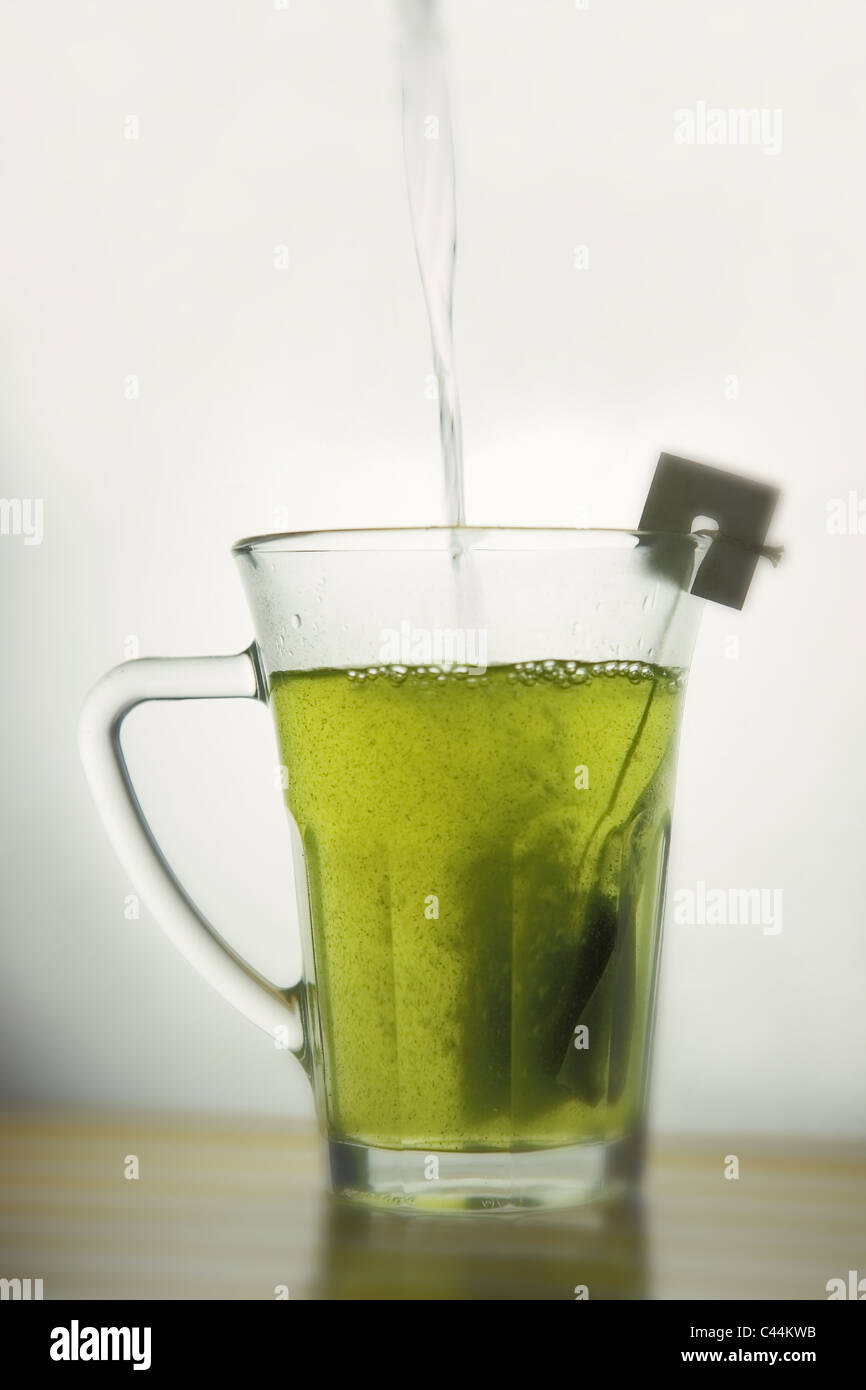 verser de l'eau chaude dans une tasse de thé vert sencha matcha. Isolé, espace de copie. Banque D'Images