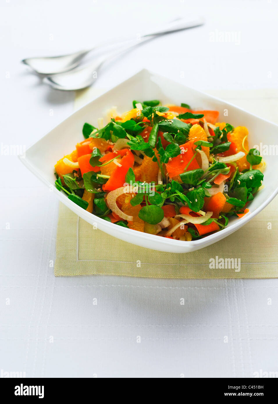 Bol de salade de carottes et d'orange sur fond blanc, close-up Banque D'Images