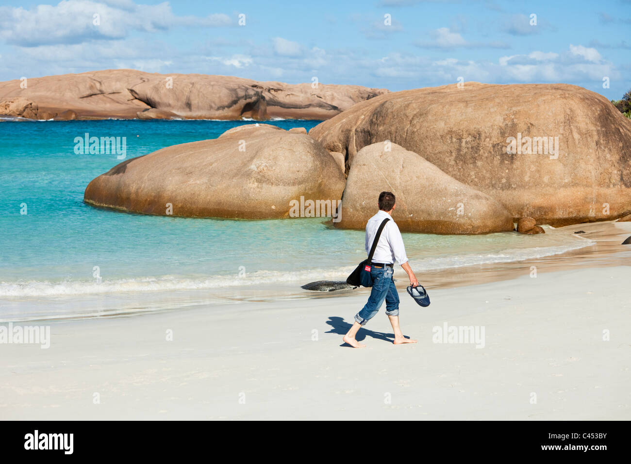 Homme marchant le long de la plage au crépuscule. Esperance, Australie occidentale, Australie Banque D'Images