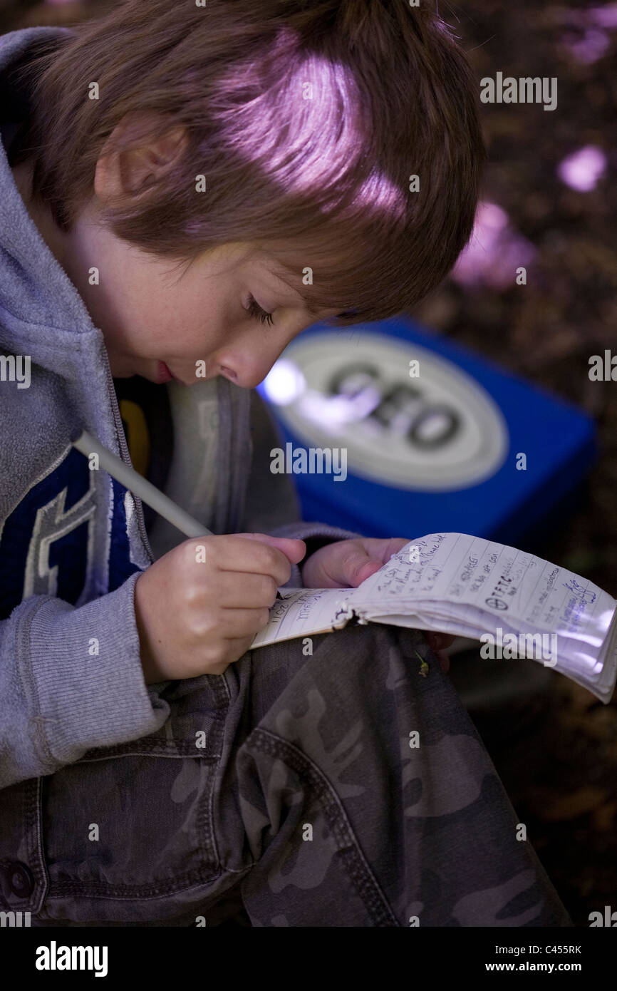 L'écriture de l'enfant dans le log book trouvé dans la zone de chasse au trésor Banque D'Images