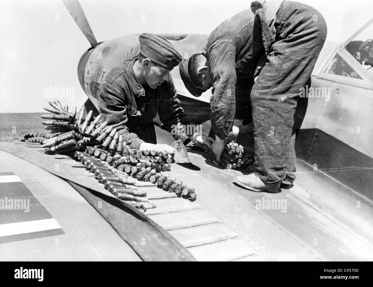 Le personnel au sol de munitions rechargement dans un avion de chasse, 1942 Banque D'Images
