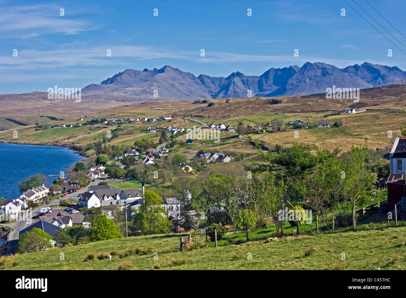 Vue du dessus vers le village de Skye Carbost Cuillin Hills avec la distillerie de Whisky Talisker au premier plan. Banque D'Images