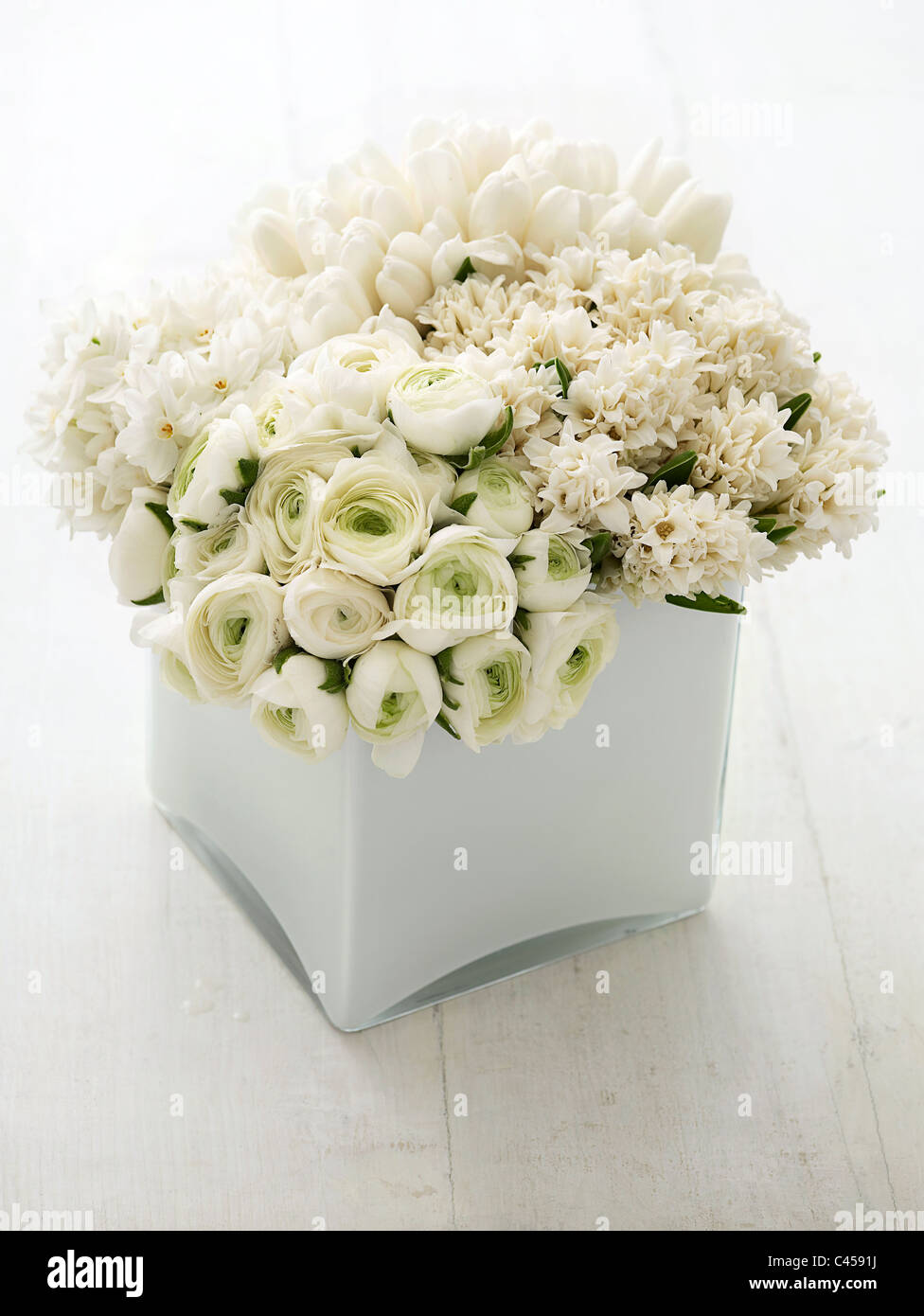 Arrangement de fleurs dans un vase blanc frais, y compris les narcisses, jacinthes, tulipes, ranunculas, close-up Banque D'Images