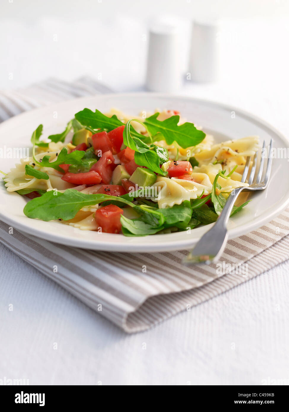 Plaque de base de l'avocat, tomate et roquette farfalle, close-up Banque D'Images