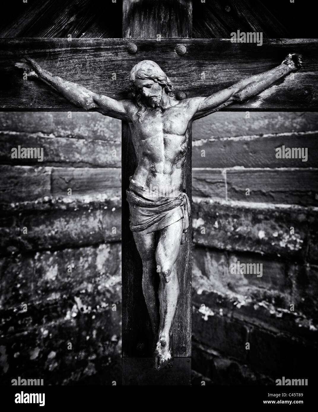 Statue de jésus christ la crucifixion sur une pierre tombale au St Bartholomew church, beaucoup Marcle Herefordshire, Angleterre Banque D'Images