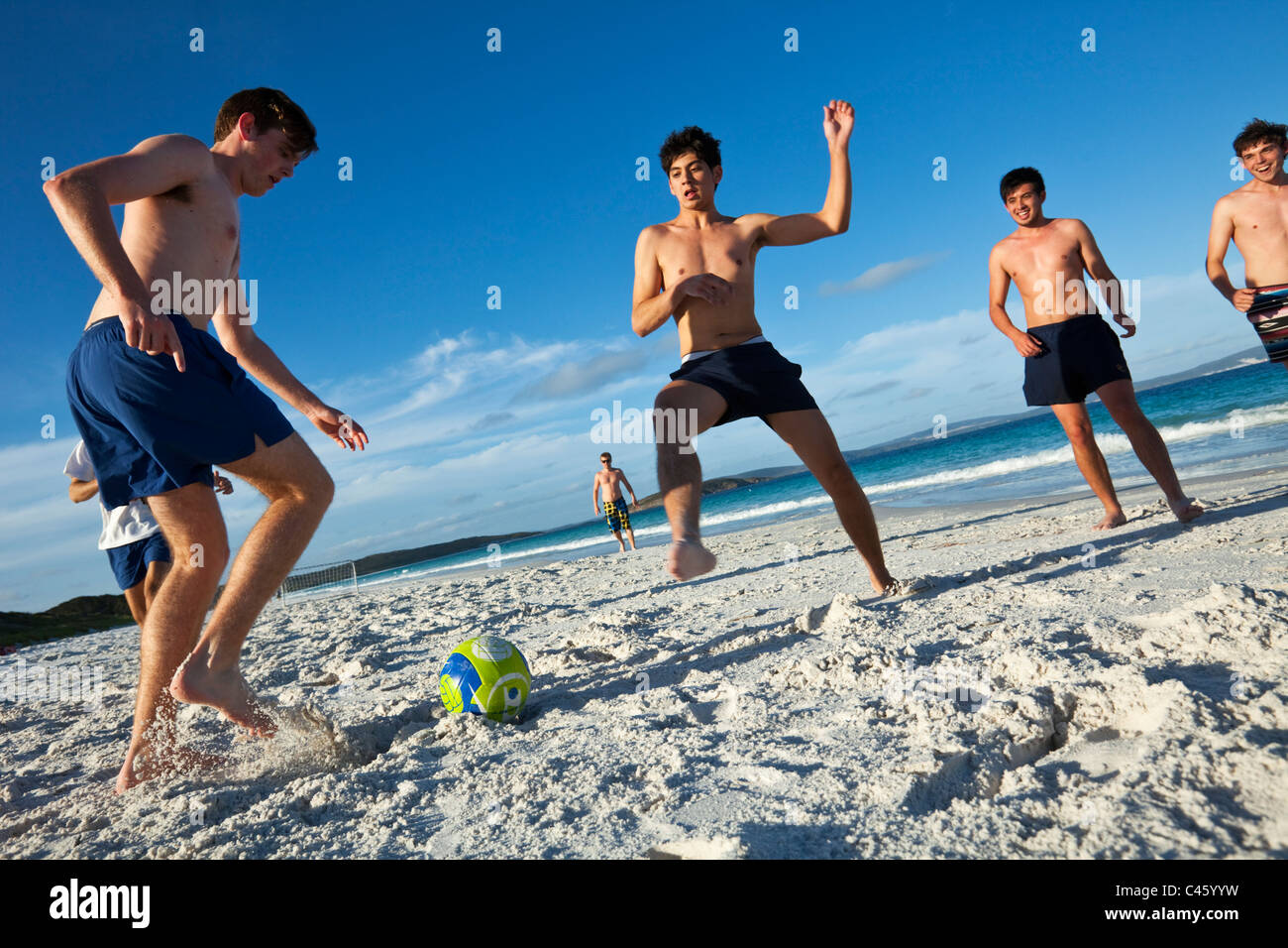 Les jeunes hommes jouant au foot de plage. Goode, plage de la baie Frenchman, Albany, Australie occidentale, Australie Banque D'Images