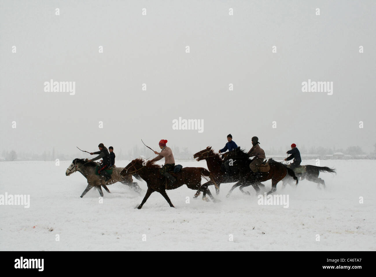 L'exécution de cavaliers sur la neige, le Kirghizistan Banque D'Images