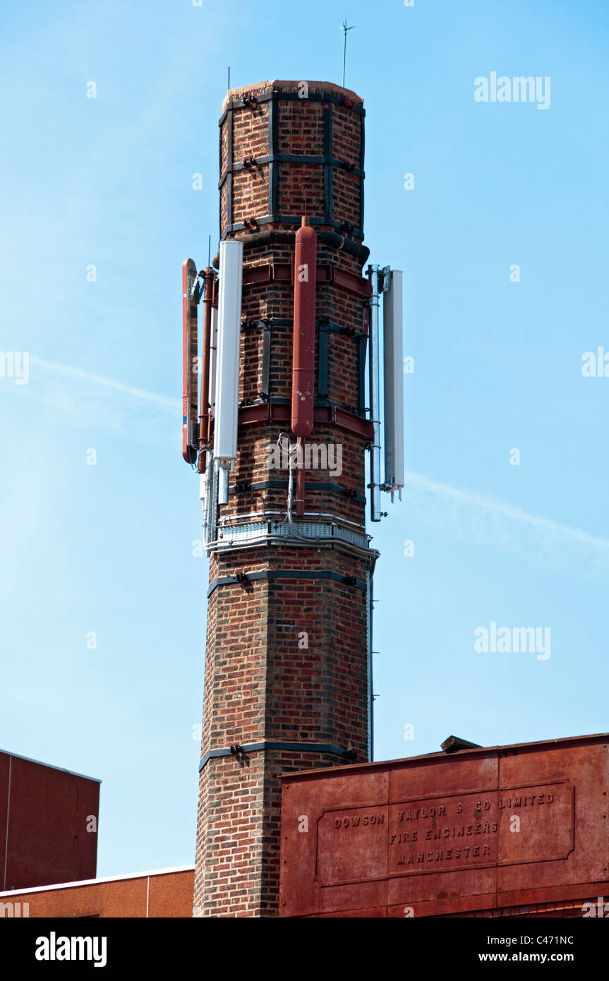 Ancienne cheminée d'usine utilisée pour les téléphones portables, antennes émettrices Ashton en vertu de Lyne, Tameside, Manchester, Angleterre, RU Banque D'Images