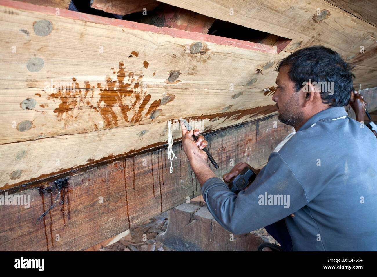 Calfeutrer l'homme d'un bateau. Chantier naval. L'île de Diu. Le Gujarat. L'Inde Banque D'Images
