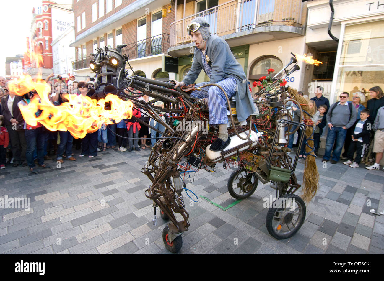 Un artiste de rue de feu chevauche son cheval de fer au cours de la 2011 Brighton Festival Fringe Banque D'Images