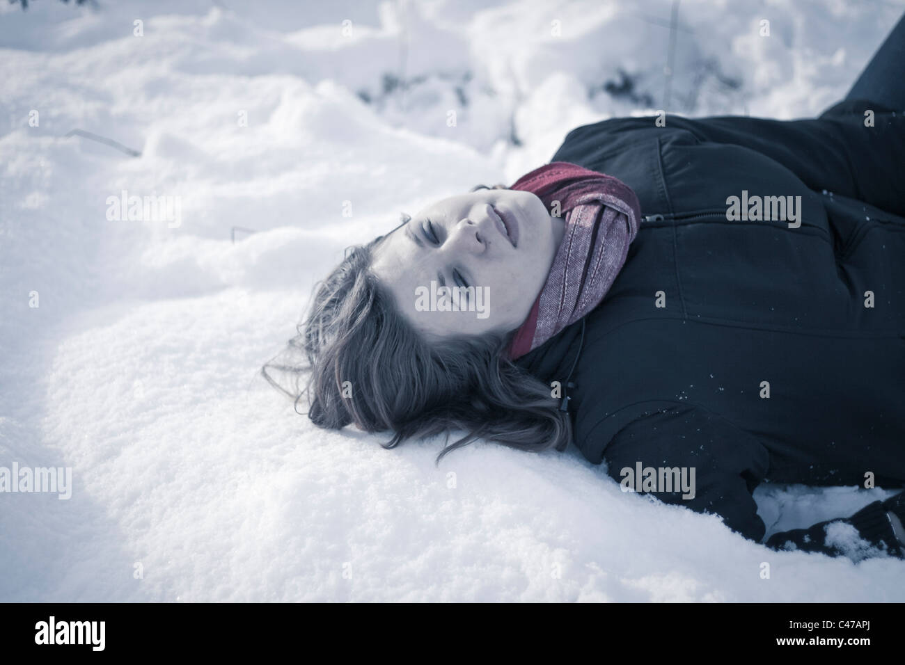 Mort de froid - concept. Jeune modèle féminin allongé sur la neige. Banque D'Images