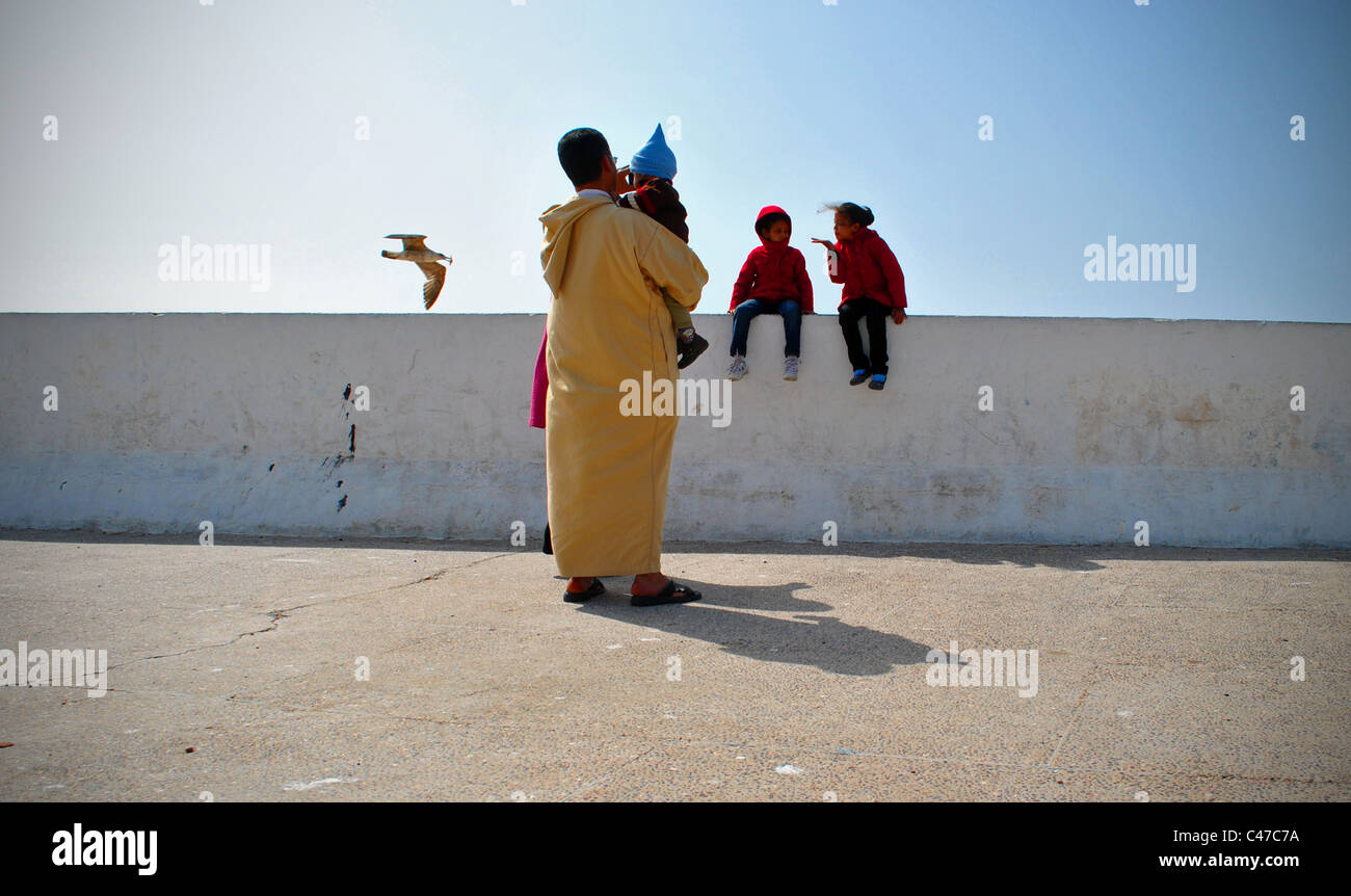 Famille marocaine par la digue à Essaouira, Maroc Banque D'Images