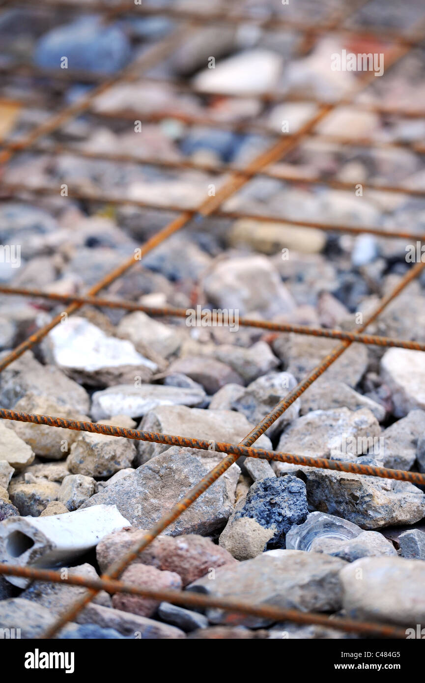 Le renforcement du béton treillis d'acier qui est représenté sur le hardcore ( casse briques, pierres) Banque D'Images