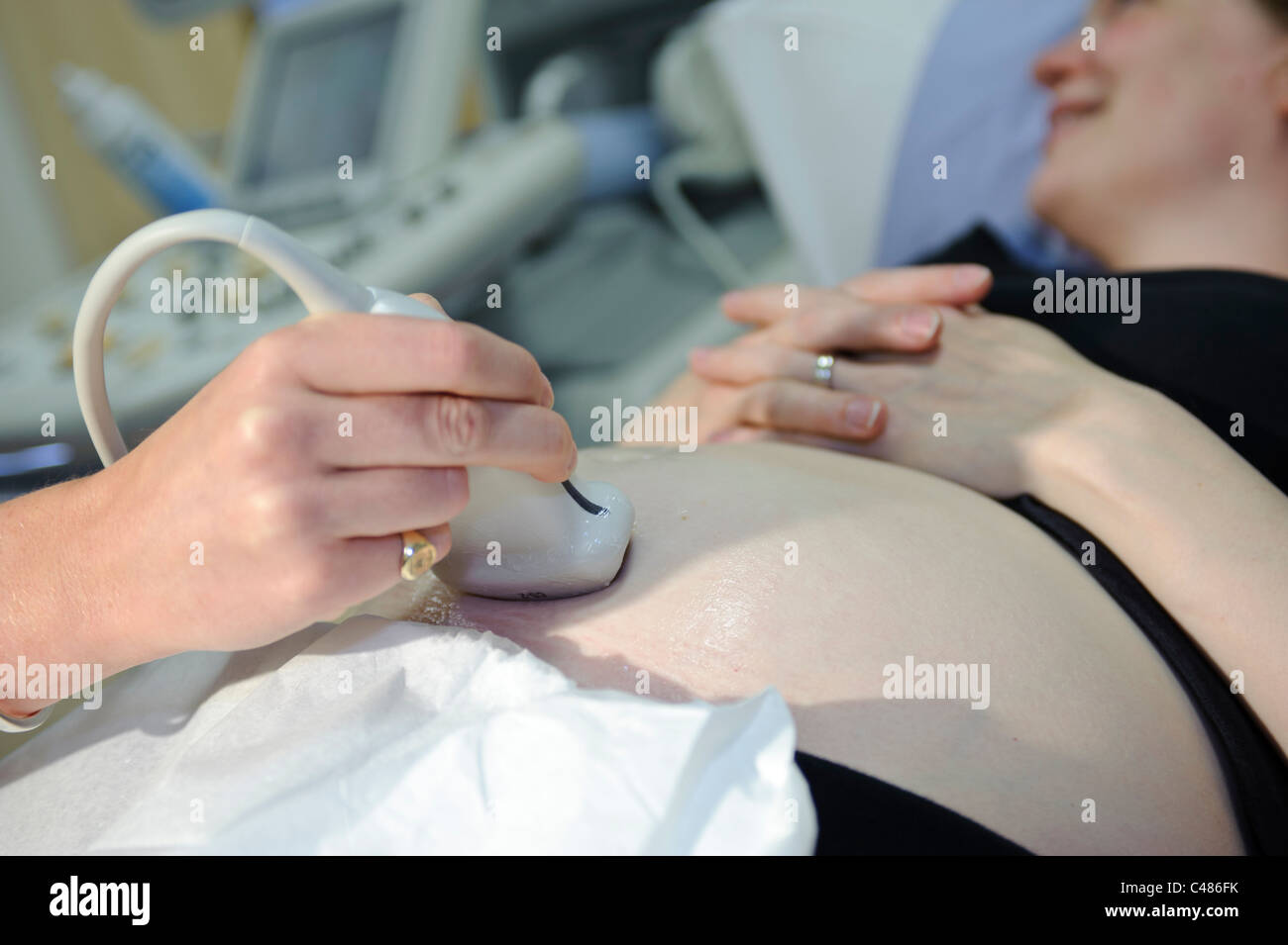 Femme enceinte sur la table de consultation du patient ayant échographie par femme médecin Banque D'Images