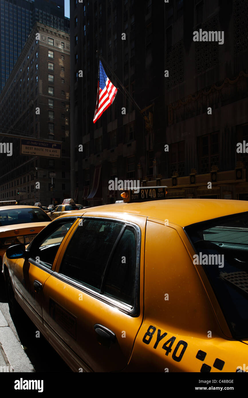 Un taxi jaune et un drapeau américain, New York City, USA Banque D'Images