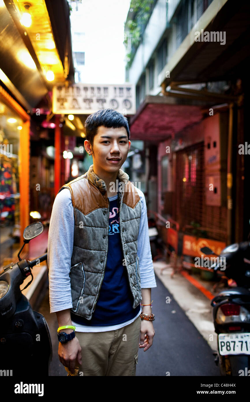 Portrait d'un jeune homme dans l'une des nombreuses petites ruelles de boutiques de vêtements à Ximending, Taipei, Taiwan, le 24 octobre 2010. Banque D'Images