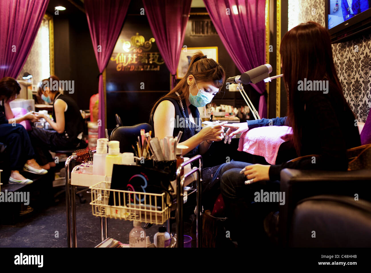 Les jeunes femmes s'pierres décoratives mis dans leurs ongles à 'Cinderella' dans le quartier branché et élégant Ximending, Taipei, Taïwan, Novembre Banque D'Images