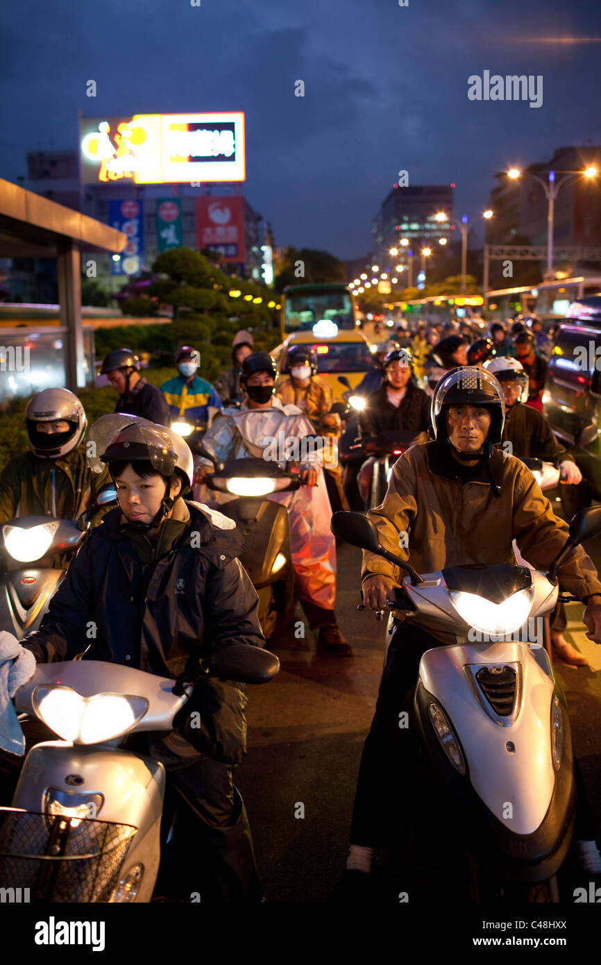 En attente de la lumière. Les triporteurs sont le principal moyen de transport dans la ville de Taipei, l'un des pays les plus densily Banque D'Images