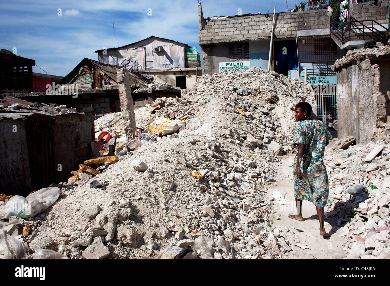 Femme marche à travers les décombres à Port-au-Prince. Banque D'Images