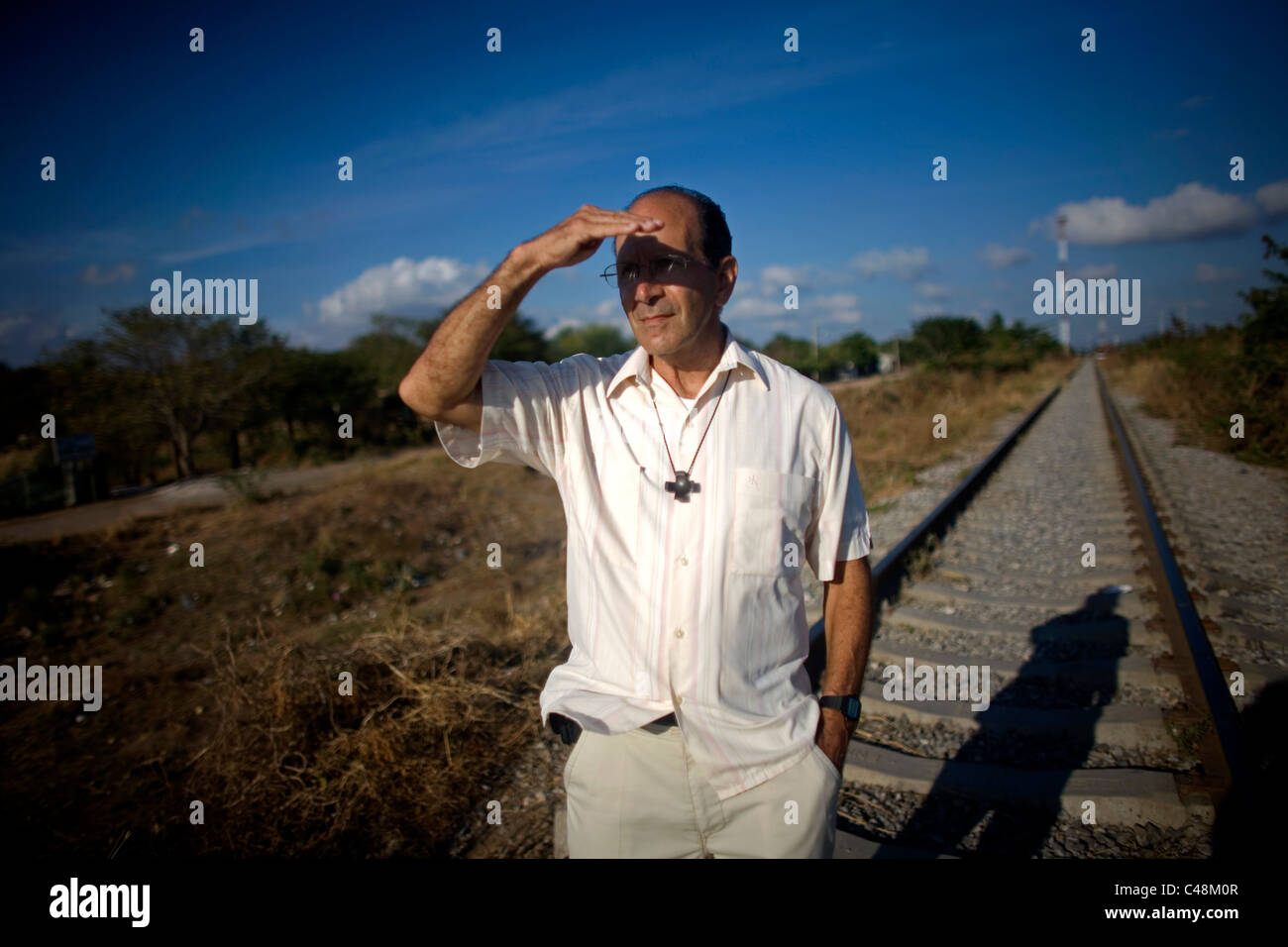 Prêtre catholique, Alejandro Solalinde couvre ses yeux avec sa main pendant qu'il marche le long du chemin de fer en Ixtepec, état de Oaxaca, Mexique Banque D'Images