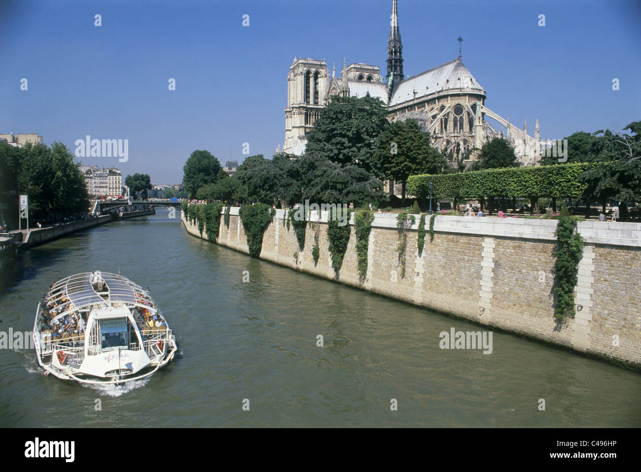 Photographie d'un bateau d'excursion sur la Seine près de la cathédrale Notre-Dame de Paris Banque D'Images