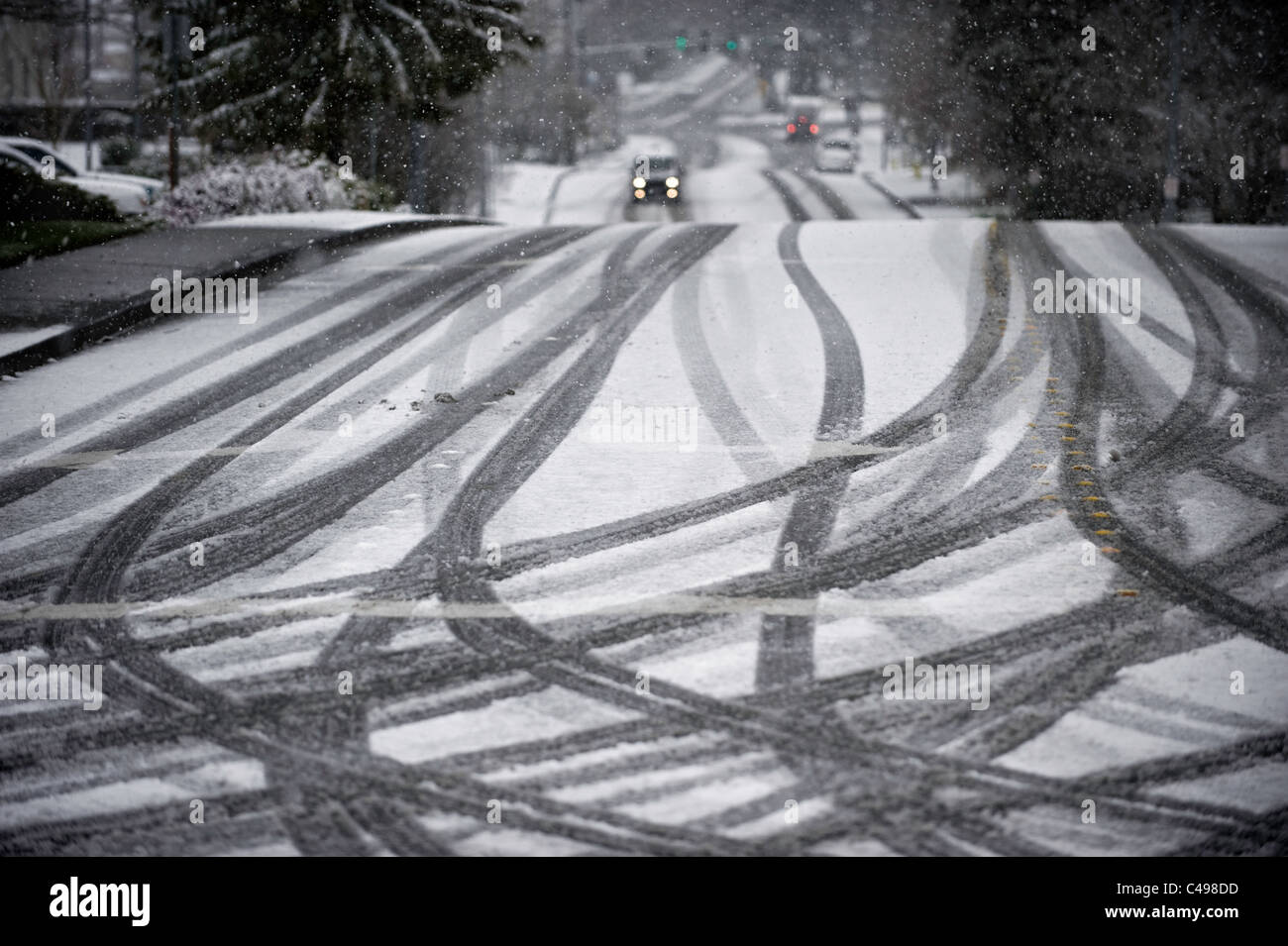 Voiture sur la route et les traces de pneus durant tempête à Seattle, Washington, États-Unis Banque D'Images