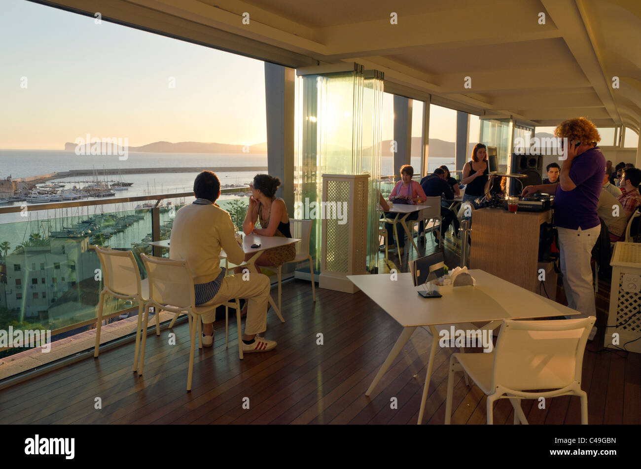 Peuple italien ayant un apéritif au coucher du soleil au bar de l'Hôtel Catalunya, Alghero, Sardaigne, Italie Banque D'Images
