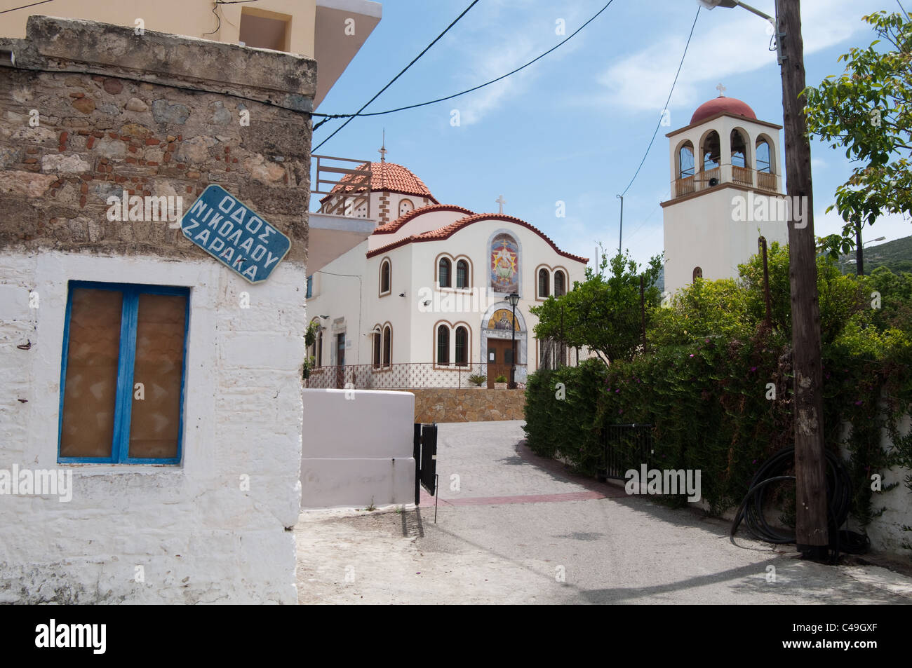 Une rue de la Kefalos Village avec l'église Saint Nikolaos en arrière-plan. L'île de Kos, Grèce. Banque D'Images