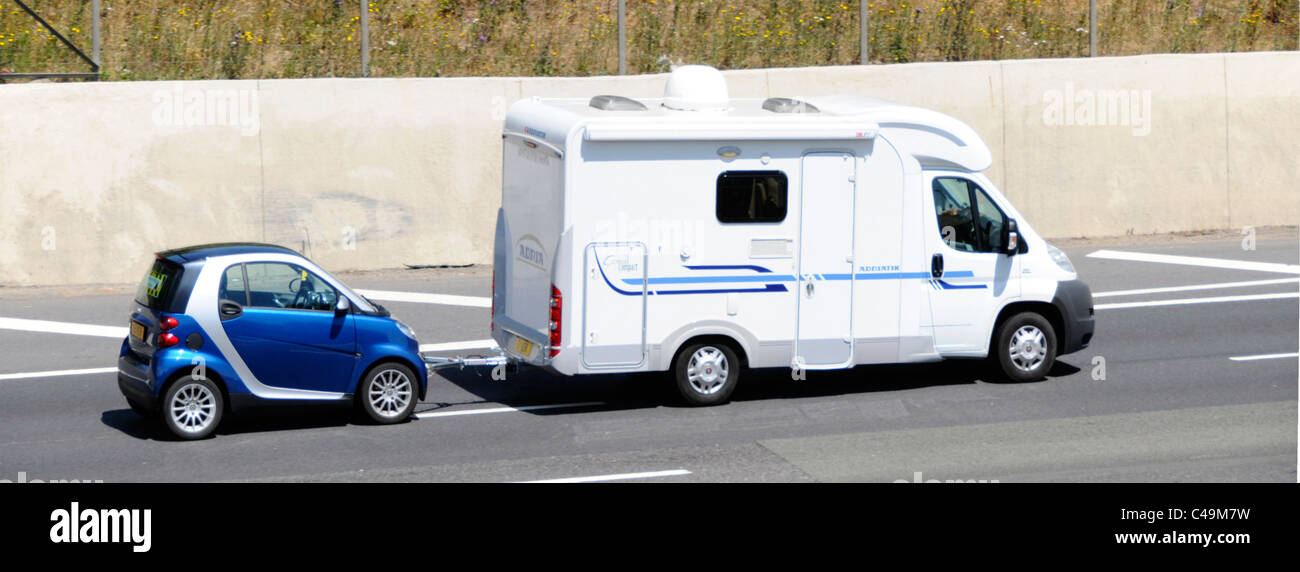 Vue de dessus à la recherche vers le bas sur le côté de la vie RV camping camping-car bleu remorquage Smart pour maison de vacances loisirs transport conduite sur autoroute britannique Banque D'Images