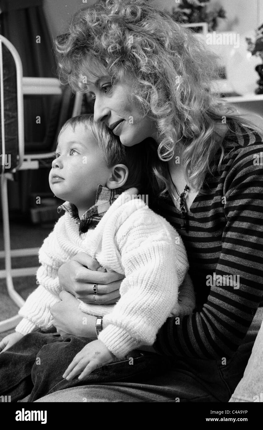 1980 Femme Au Foyer Contenu Rever Avec Bebe Dans Les Bras A La Maison Photo Stock Alamy