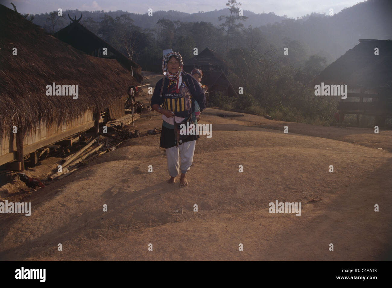 Photographie d'une mère thaïlandaise et son enfant sur son dos la marche sur la route de campagne Banque D'Images
