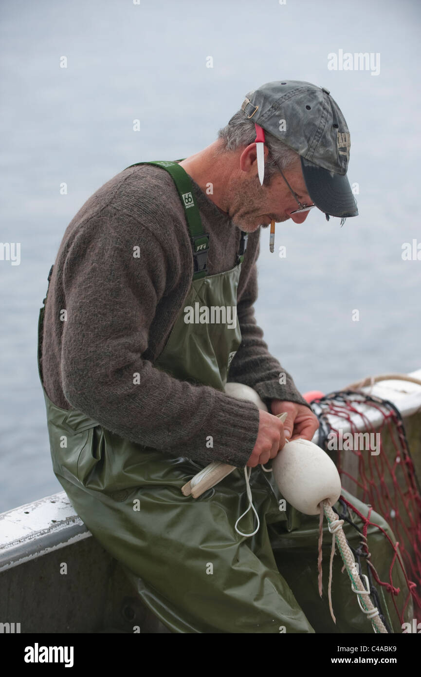 Prince William, en Alaska. Un pêcheur de saumon la couture d'un filet utilisé pour la capture de saumons roses. Banque D'Images