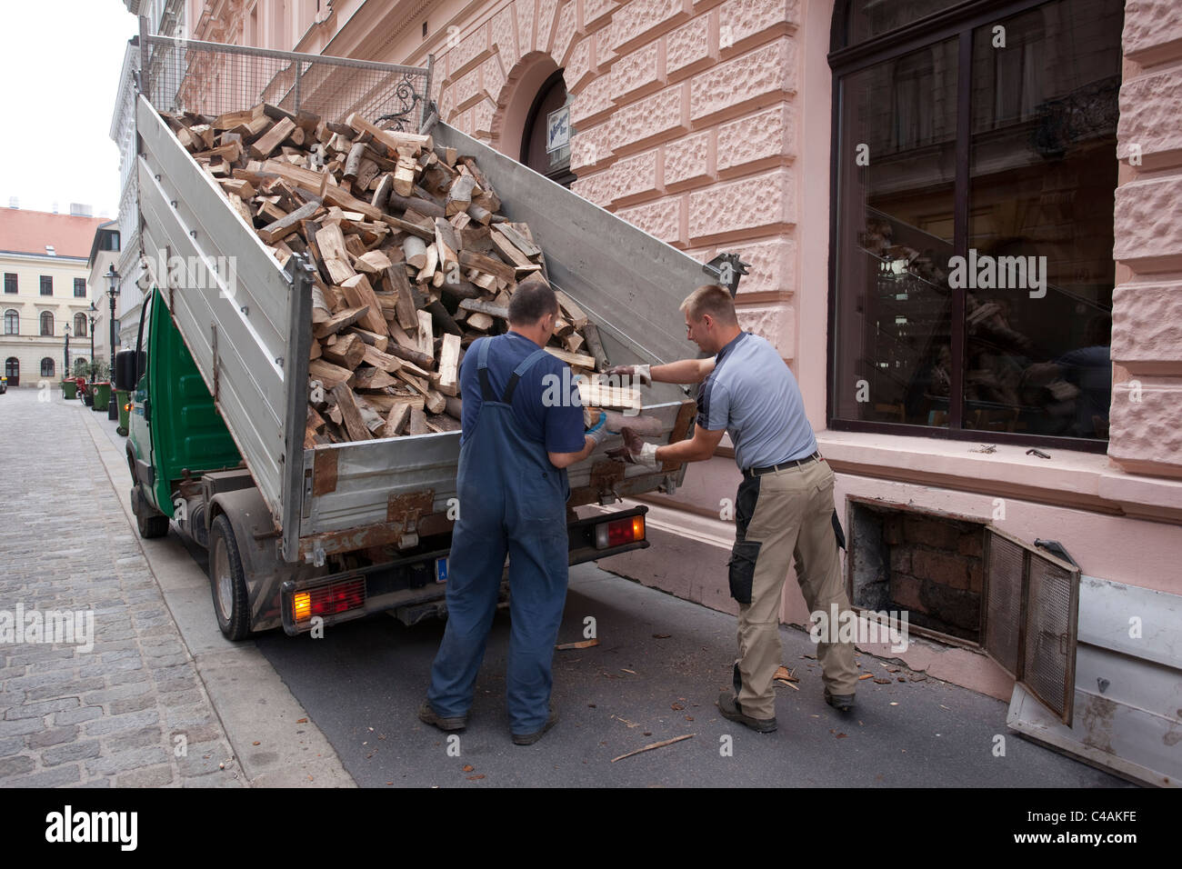 Les hommes du chargement d'un restaurant sous-sol avec du bois de chauffage au bois à Vienne, Autriche. Photo:Jeff Gilbert Banque D'Images