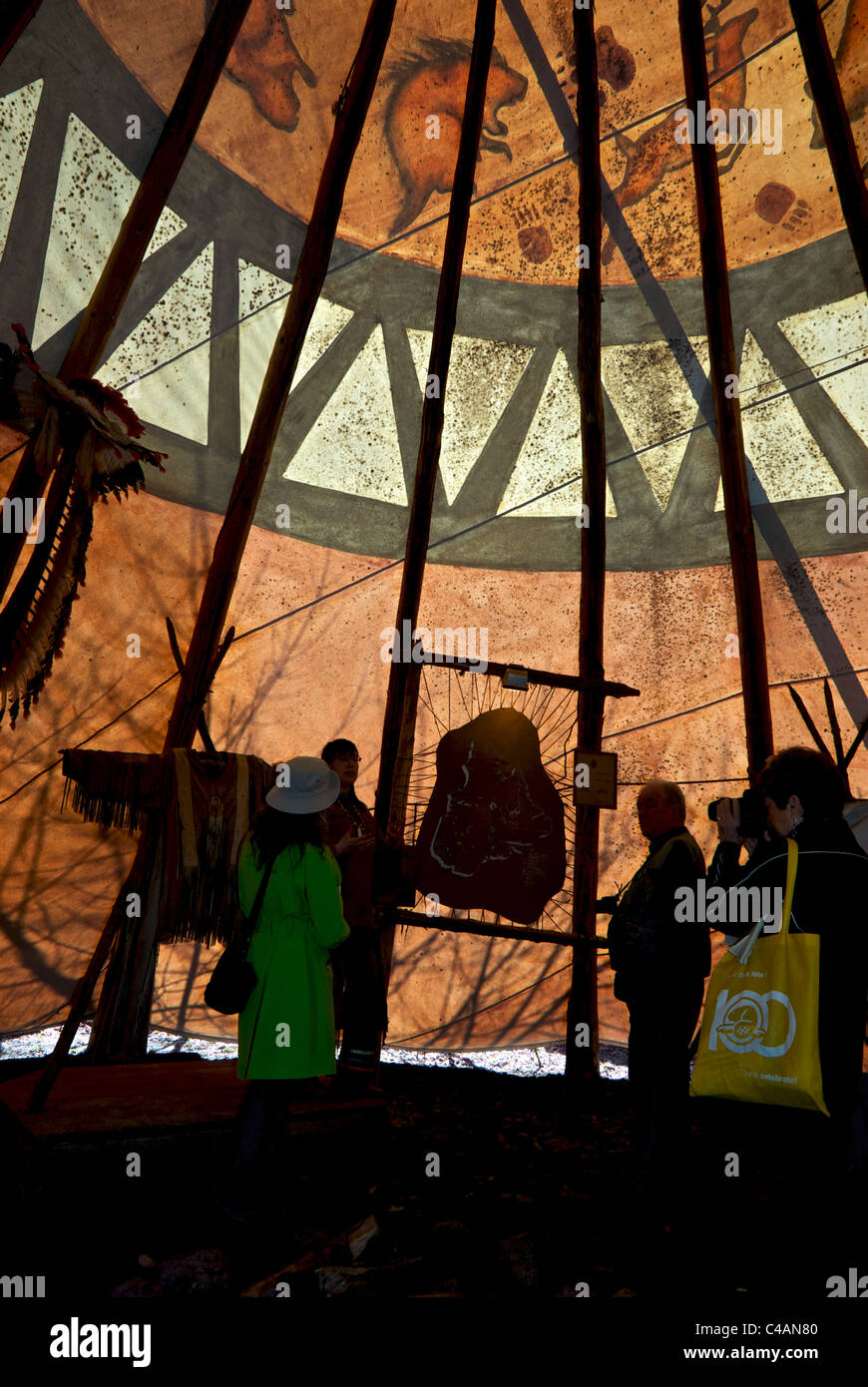Visiteurs en silhouette à l'intérieur de l'affichage traditionnel tepee loisirs village des Premières Nations huronne-wendat Wendake Québec Banque D'Images