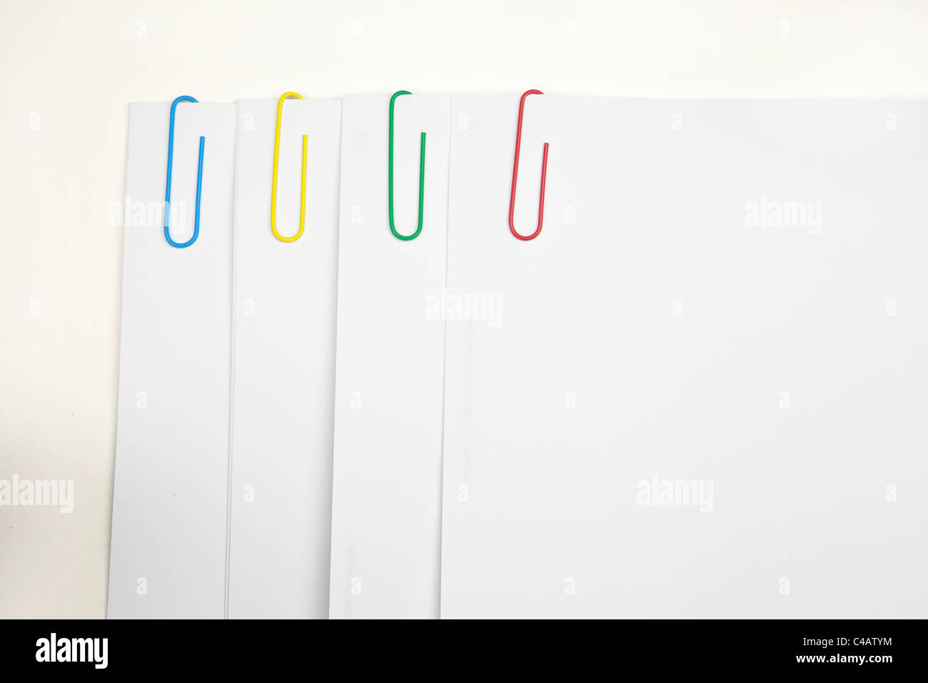 Trombone en quatre couleurs différentes - Bleu, Vert, jaune, rouge, conservez le papier, de feuilles blanches Banque D'Images