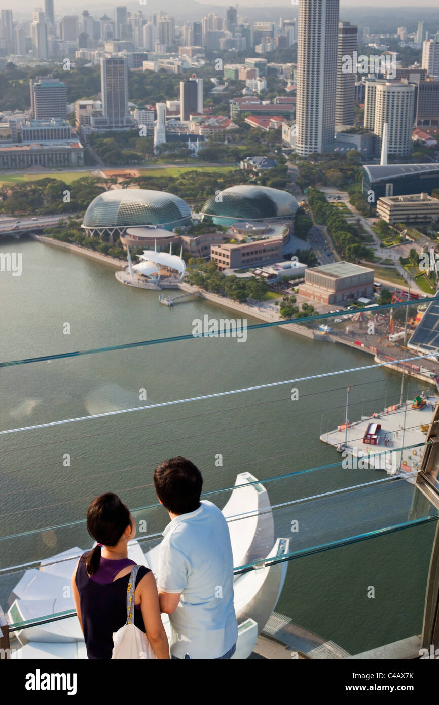 Singapour, Singapour, Marina Bay. Un couple s'ouvrent sur la ville depuis le pont d'observation de la Marina Bay Sands SkyPark. Banque D'Images